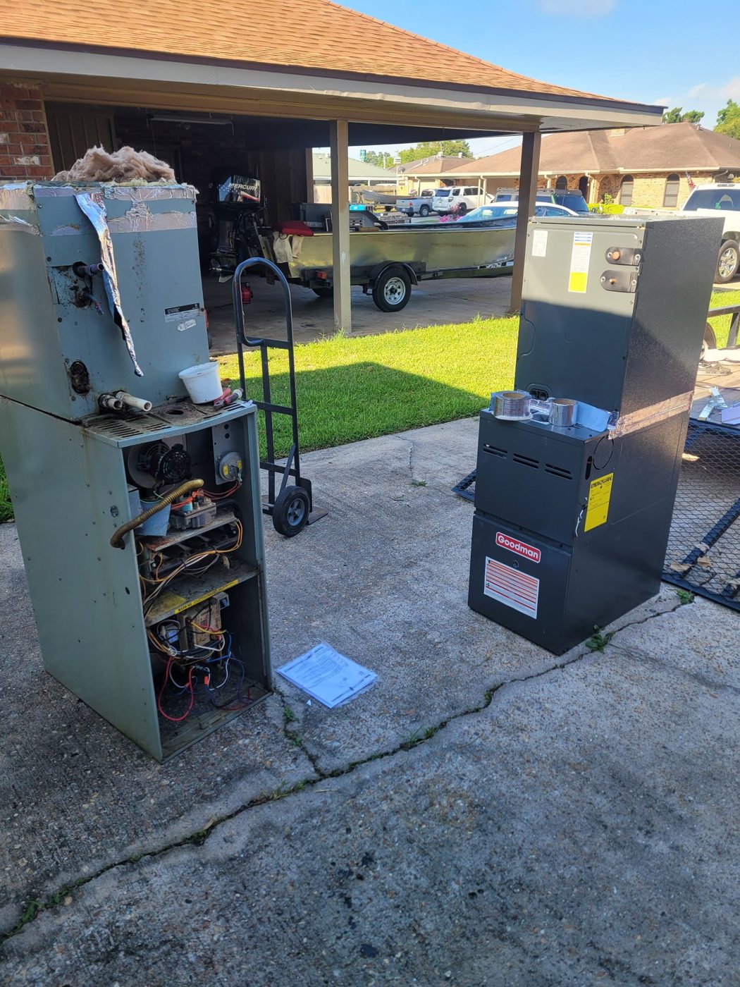 Old furnace removed next to its new Goodman replacement