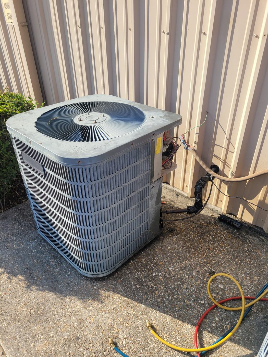 Technician service call with gauges connected to a condenser